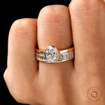 Close-up worn view of oval solitaire ring set in gold