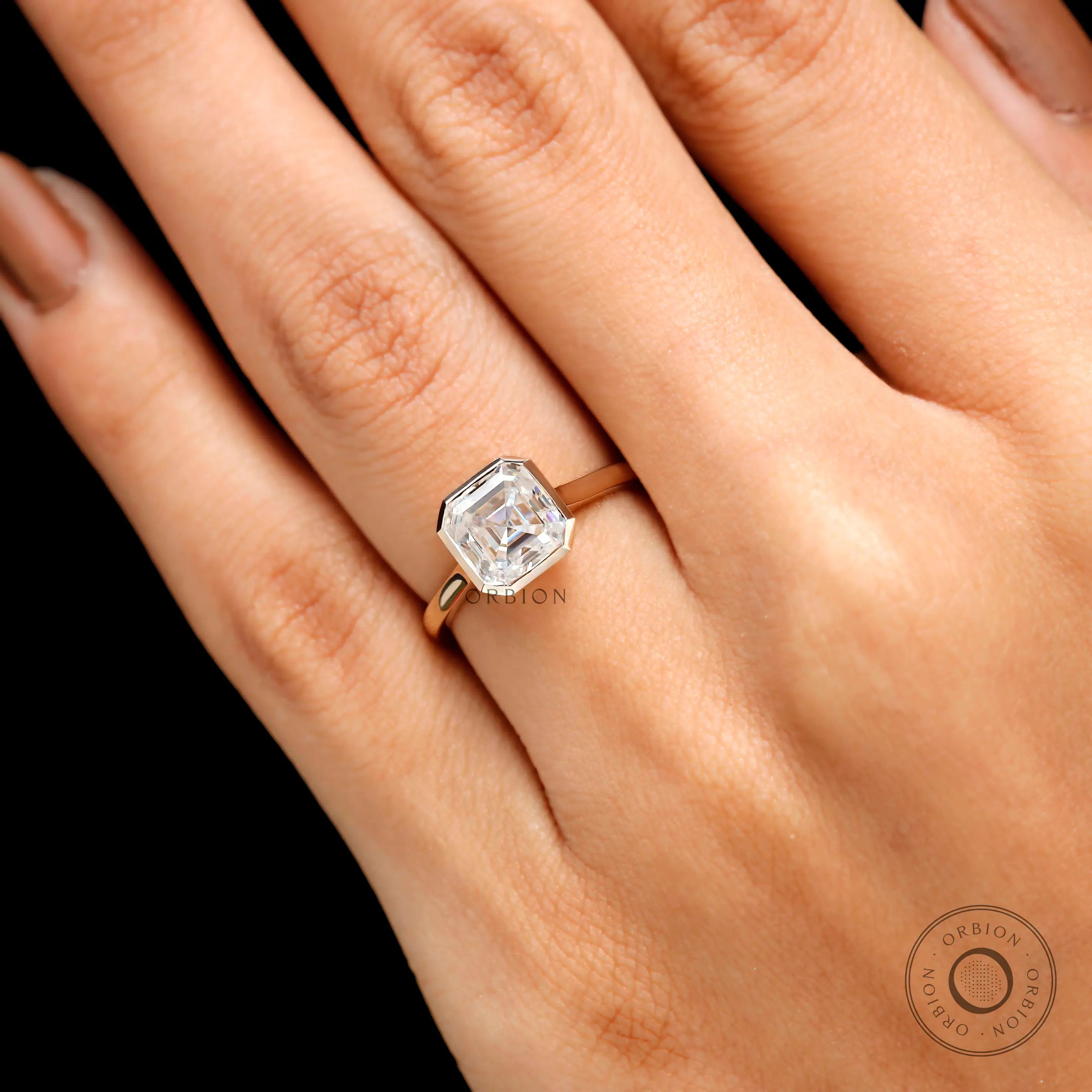 Close up asscher cut bezel cathedral solitaire ring worn on hand 