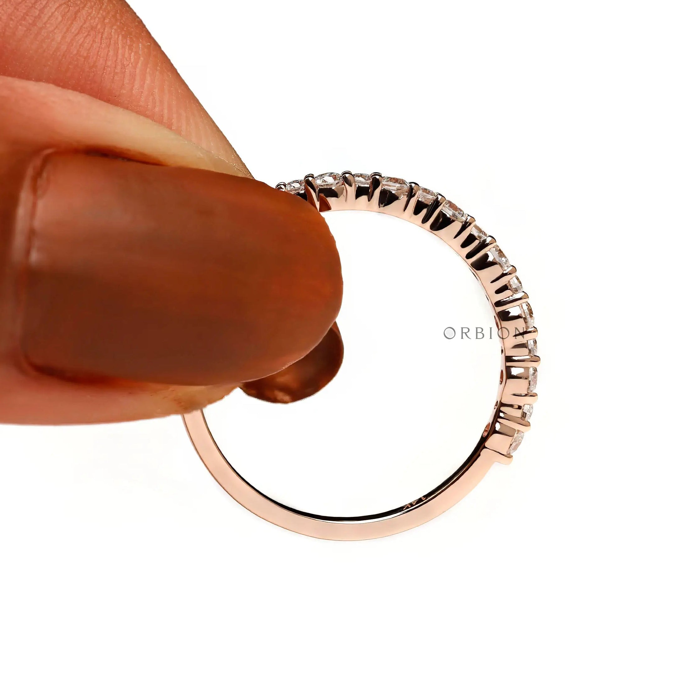 Close-up of half eternity moissanite band held