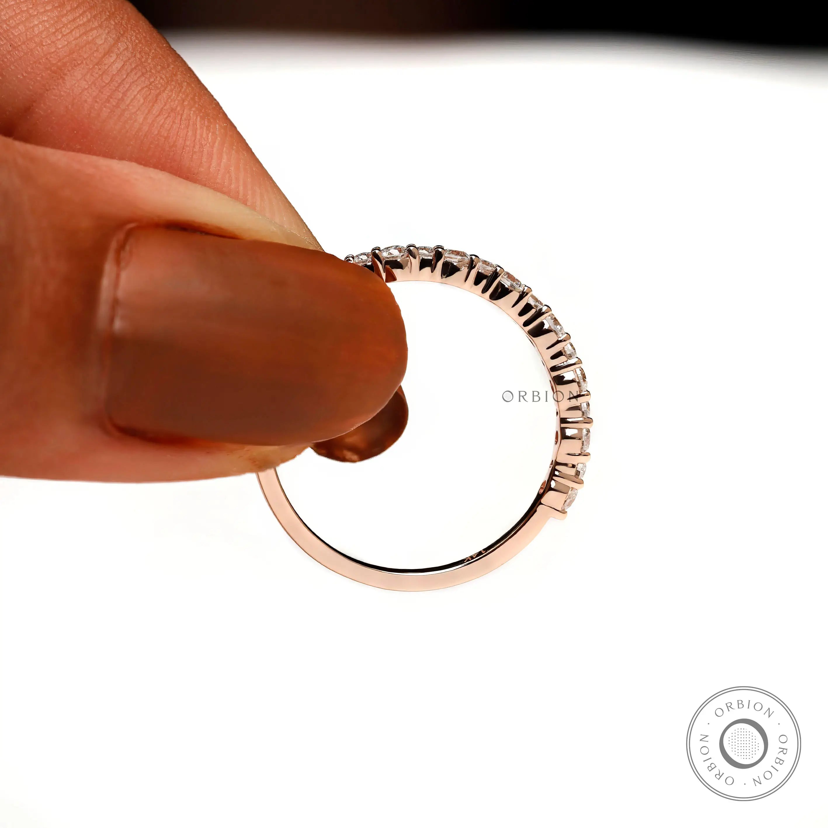 Close-up of half eternity moissanite band held