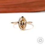 Front view oval champagne bezel ring in yellow gold on white background