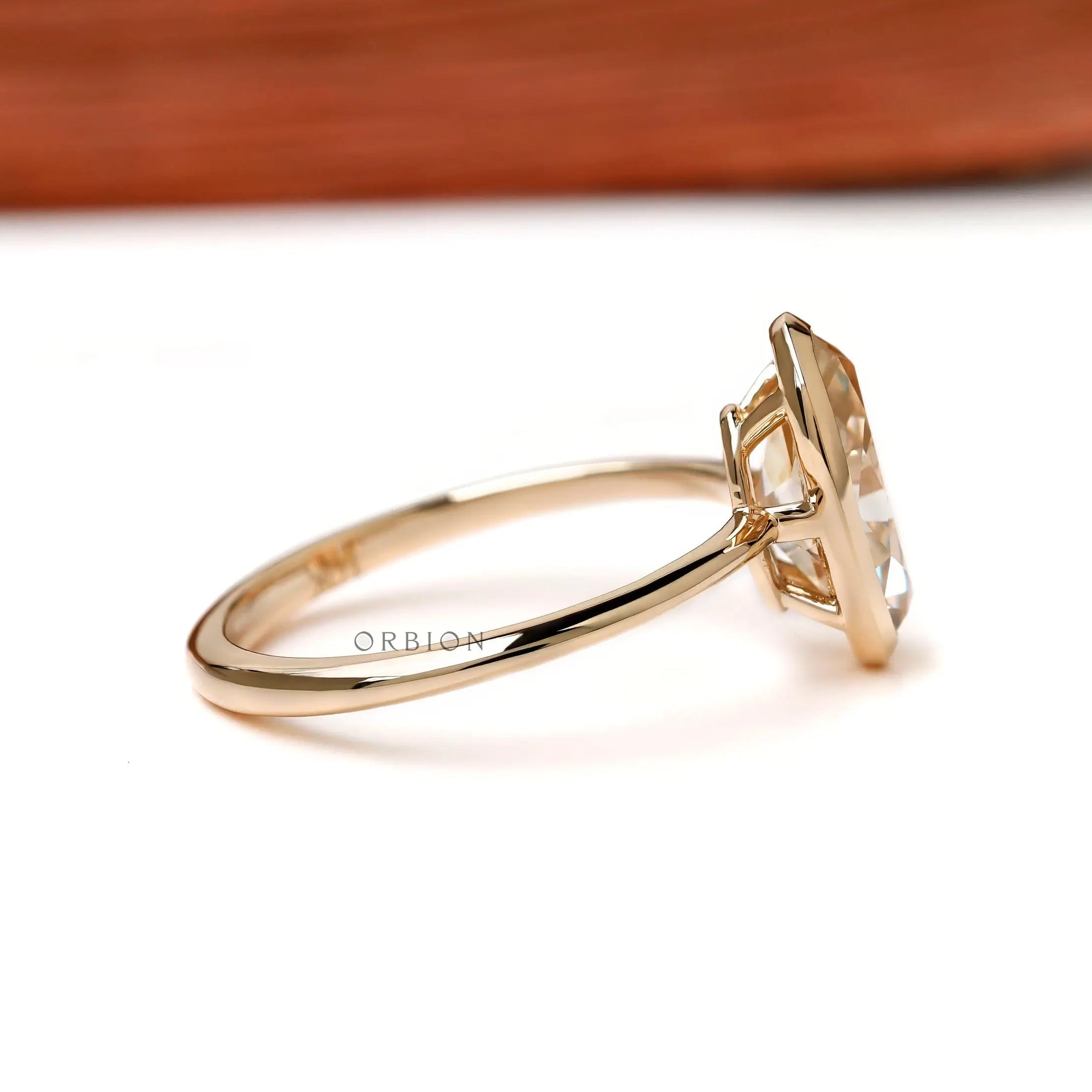 Side profile low bezel setting on slim yellow gold band