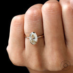Closeup on finger oval champagne stone in smooth bezel frame