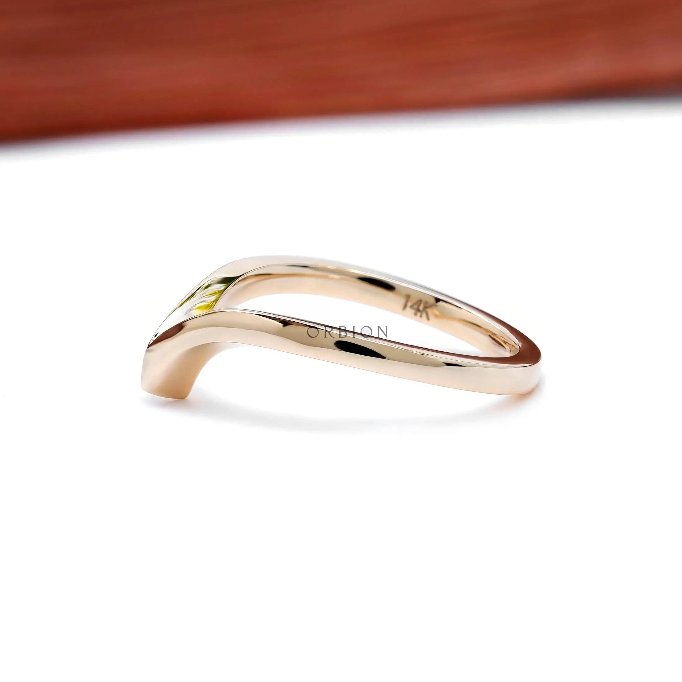 Side angle showing polished V-shaped chevron wedding band.