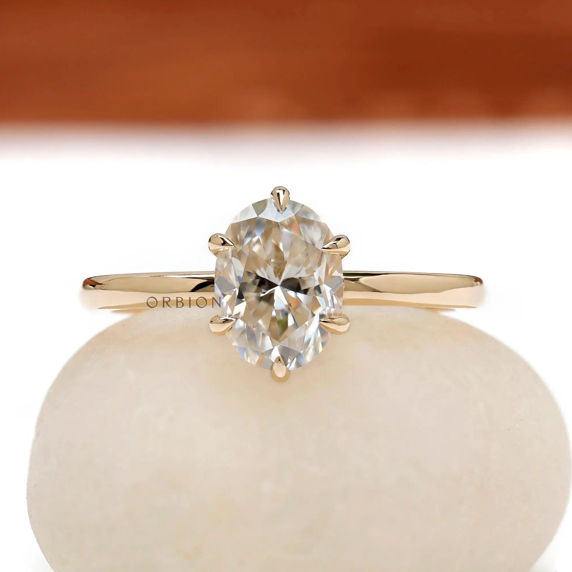 Oval moissanite solitaire ring in yellow gold, front view.