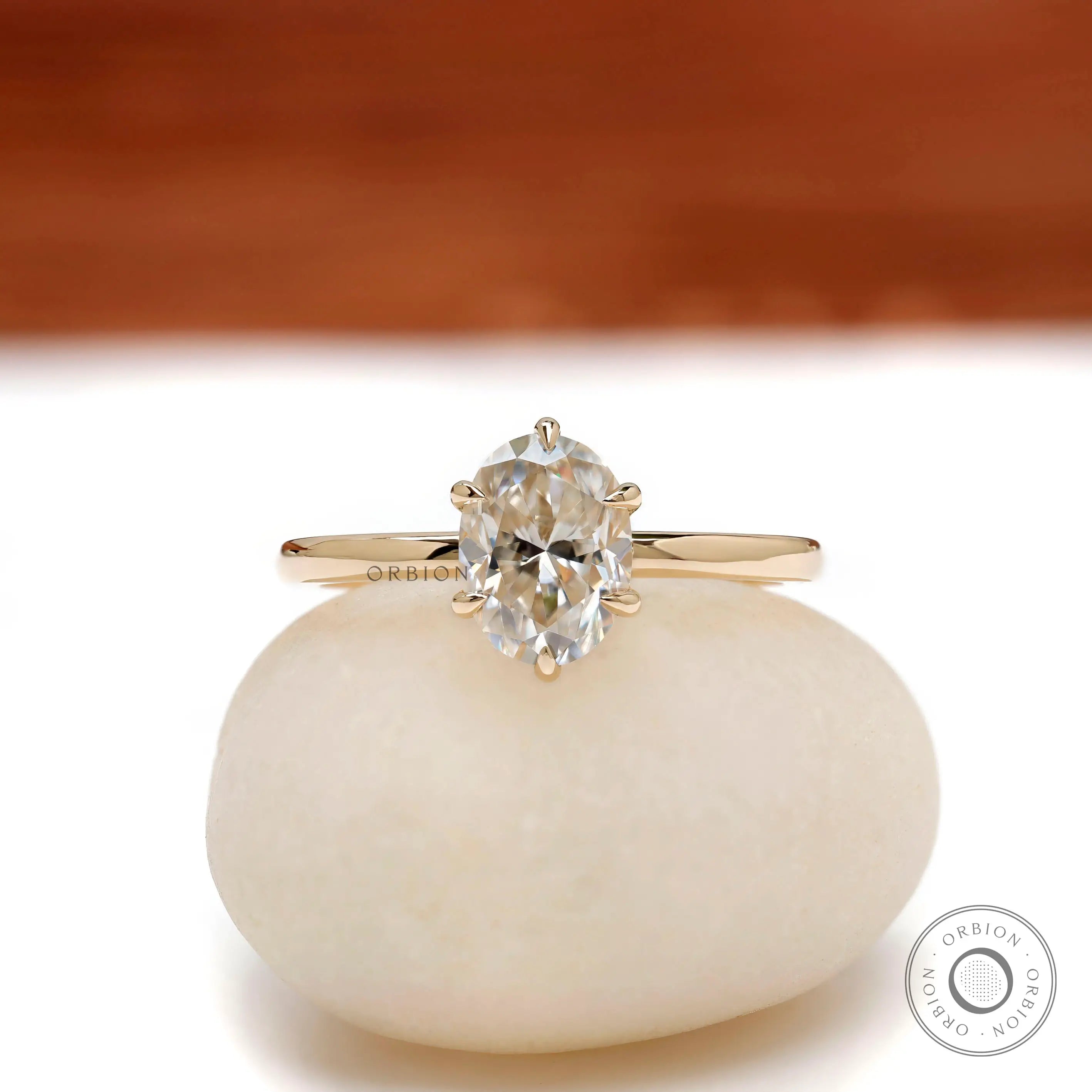 Oval moissanite solitaire ring in yellow gold, front view.