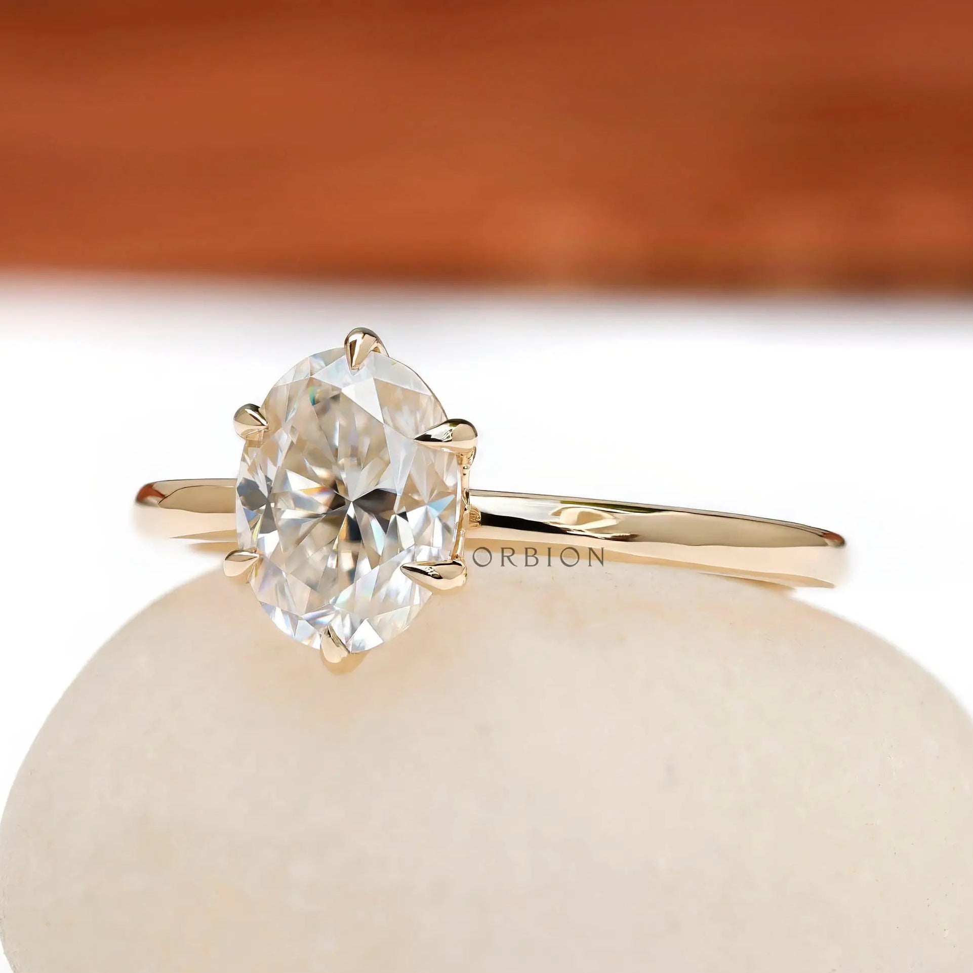 Angled view of oval moissanite six prong tulip setting solitaire ring.