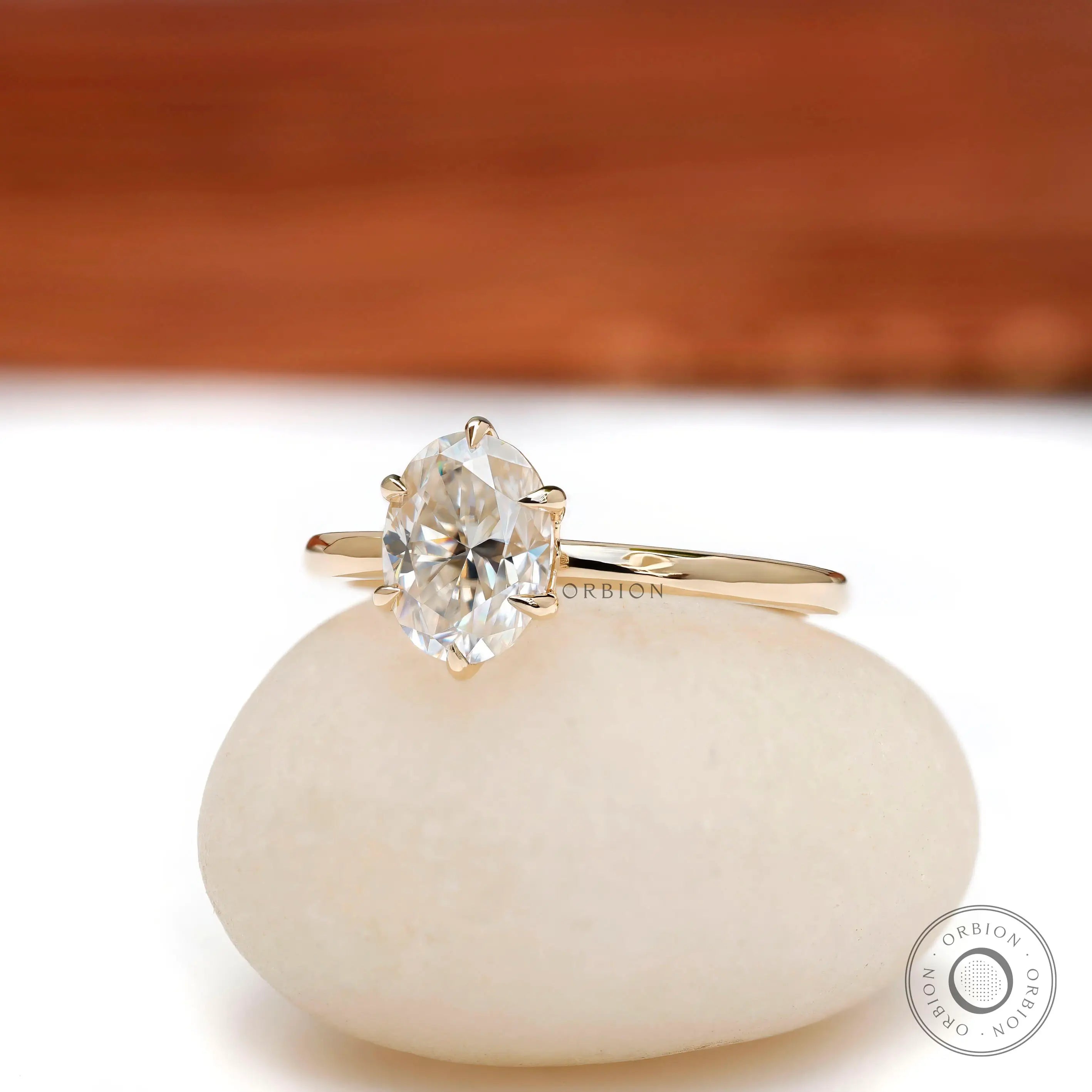 Angled view of oval moissanite six prong tulip setting solitaire ring.