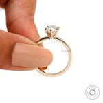 Handheld view highlighting thin band and raised oval moissanite setting.