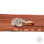 Angled view highlighting pear and emerald diamonds in yellow gold setting.