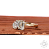 Angled view highlighting pear and emerald diamonds in yellow gold setting.