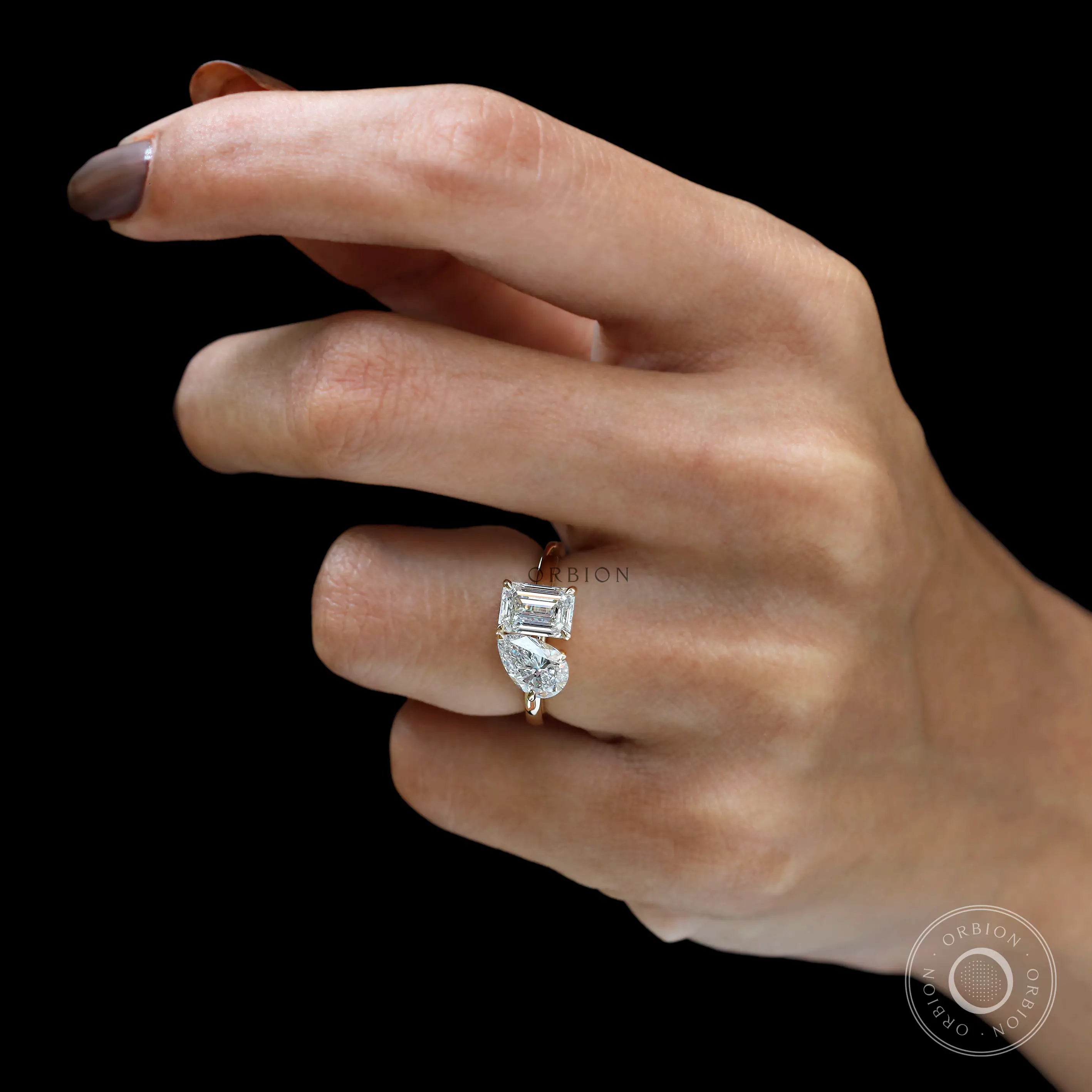 Hand model view showcasing modern two stone engagement ring sparkle.