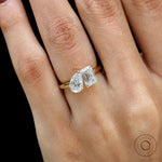 Closeup on hand showing contrast between pear and emerald lab diamonds.