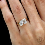 Closeup on hand showing contrast between pear and emerald lab diamonds.
