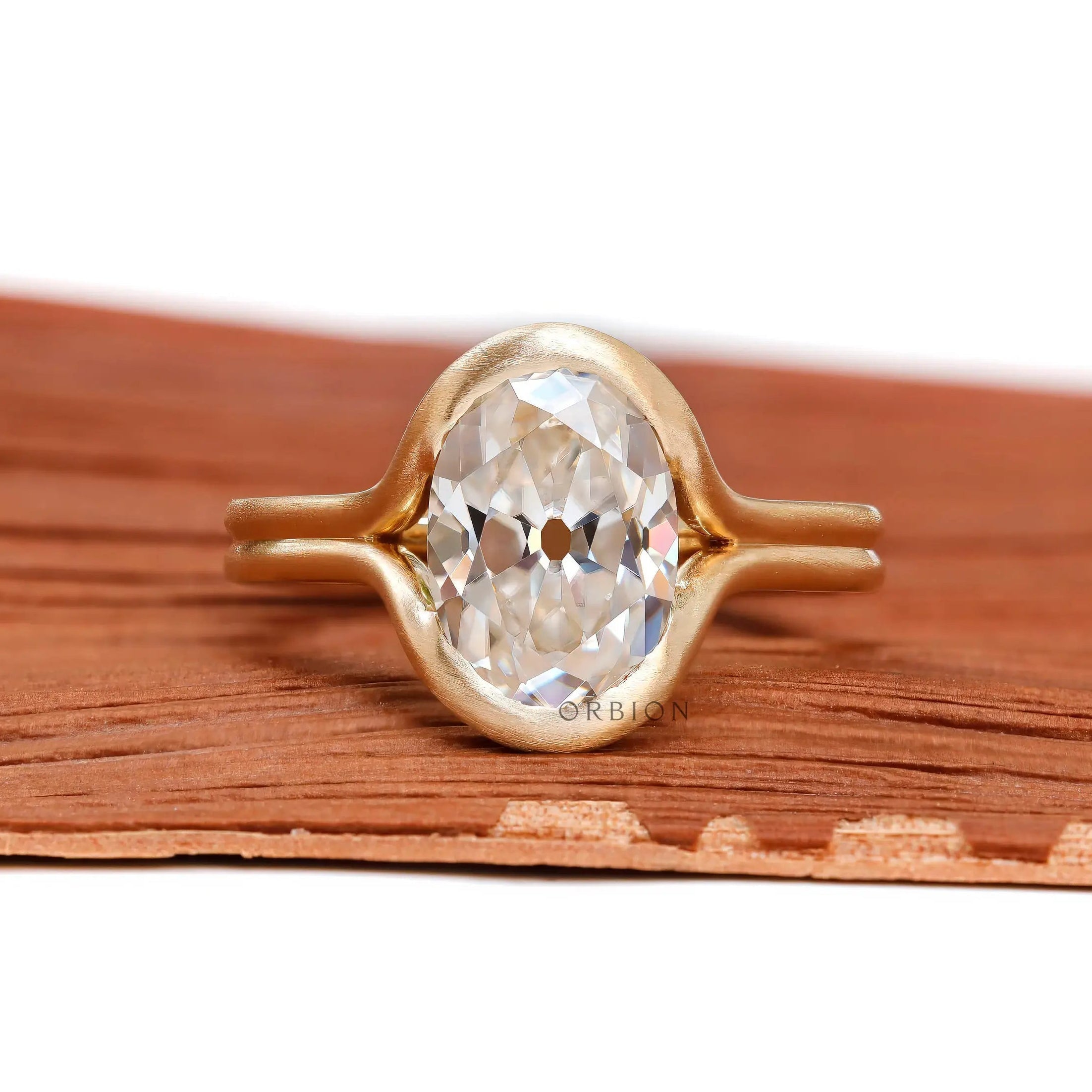 Front view matte yellow gold oval moissanite half bezel ring