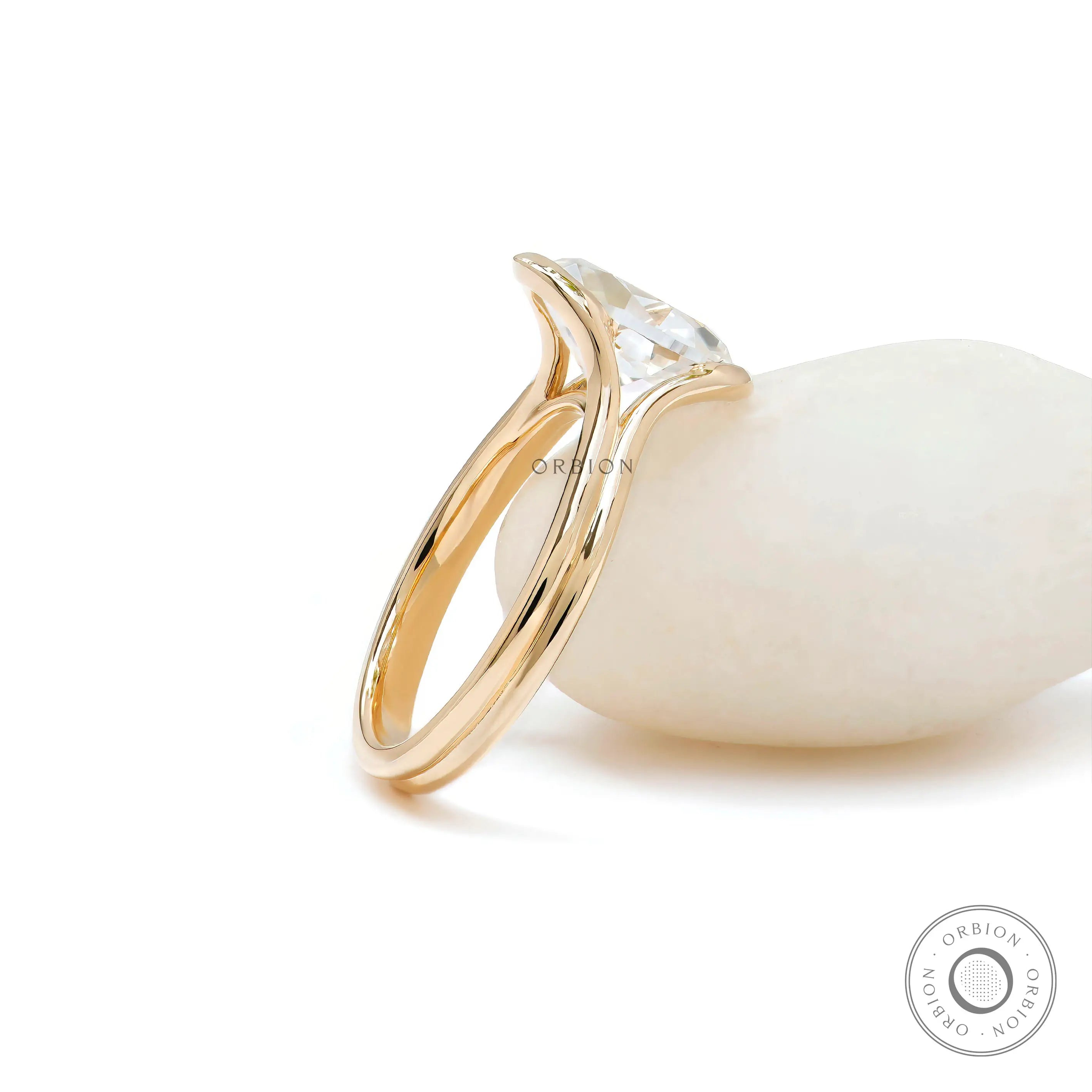 Split shank oval moissanite ring leaning on white stone