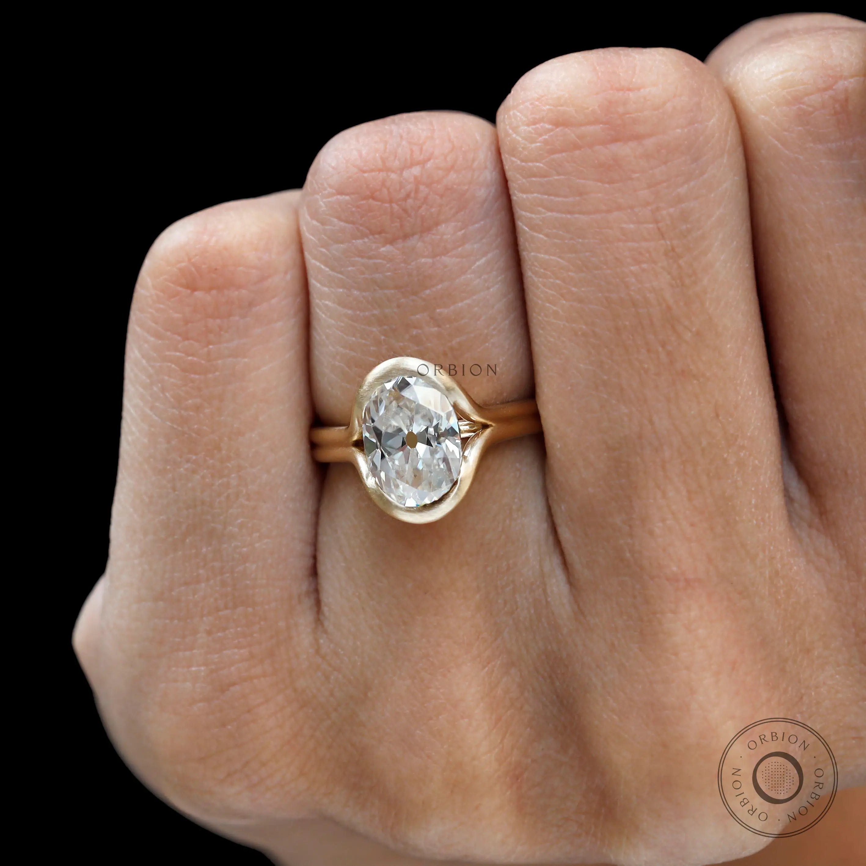 Top view on hand matte yellow gold oval ring