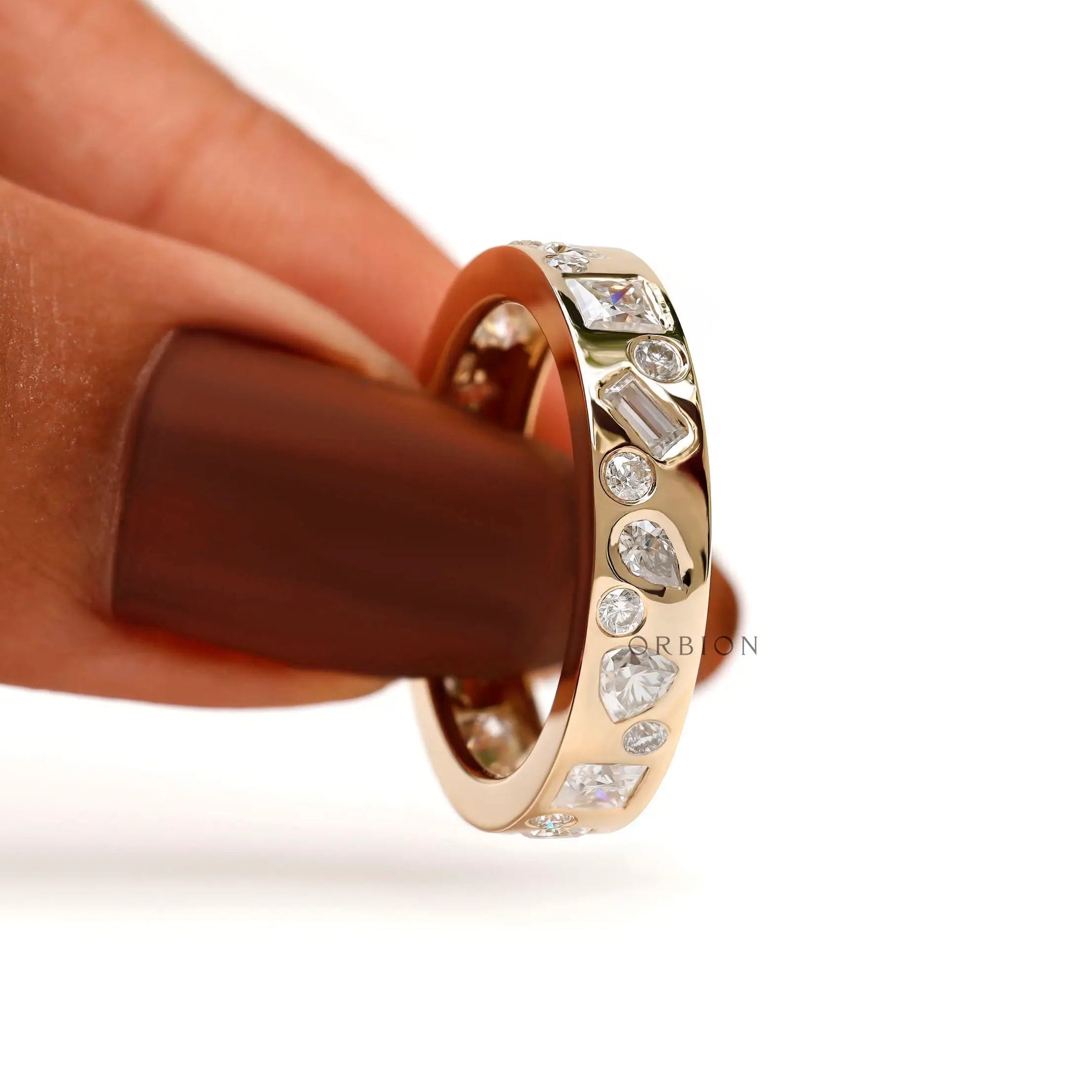 Handheld close-up highlighting baguette, pear, and round stone details.