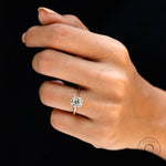 Yellow gold solitaire engagement ring with elongated cushion diamond on hand