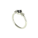 Angled view of dainty white gold ring with black moissanite.