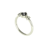 Angled view of dainty white gold ring with black moissanite.