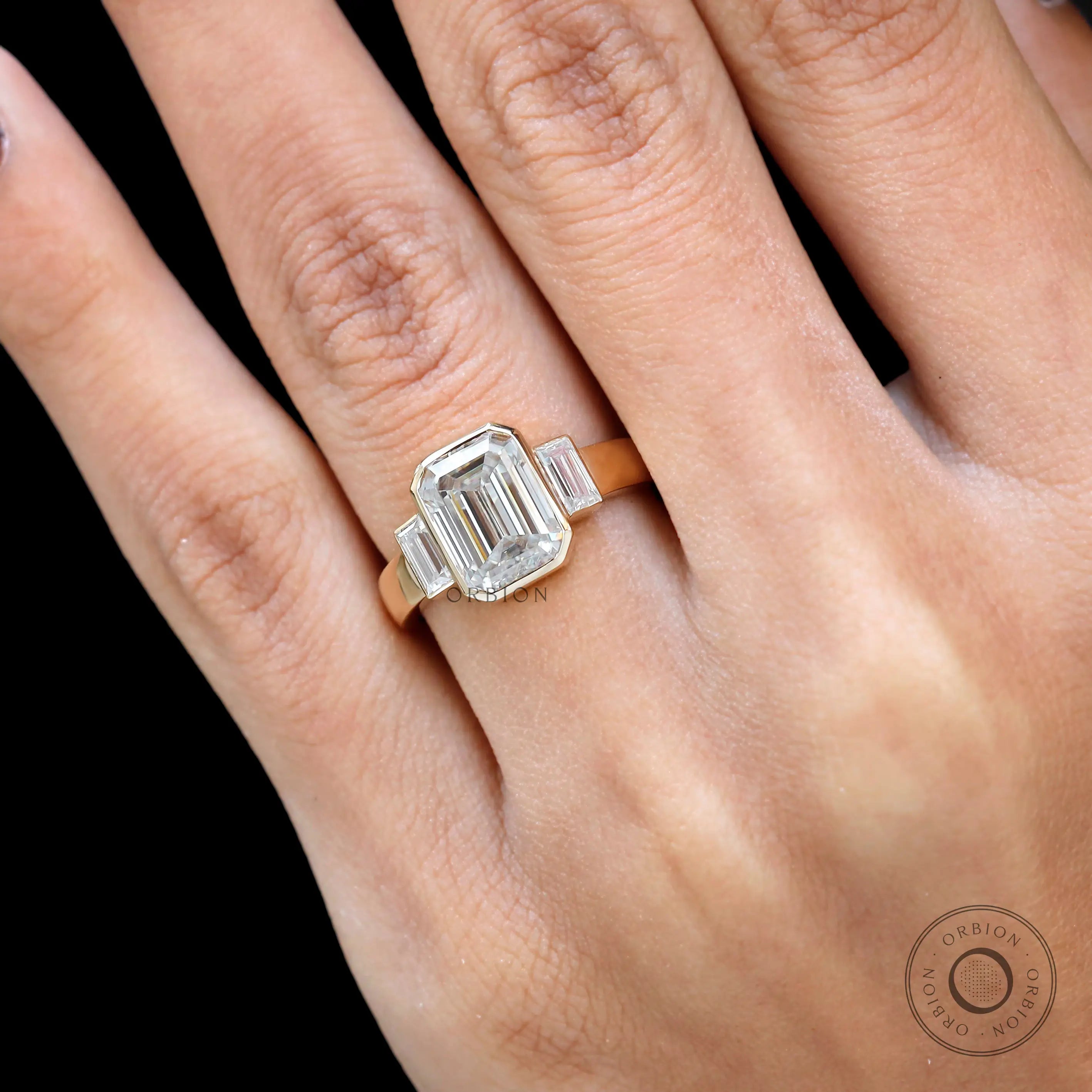 Step cut 3 stone engagement ring yellow gold close up
