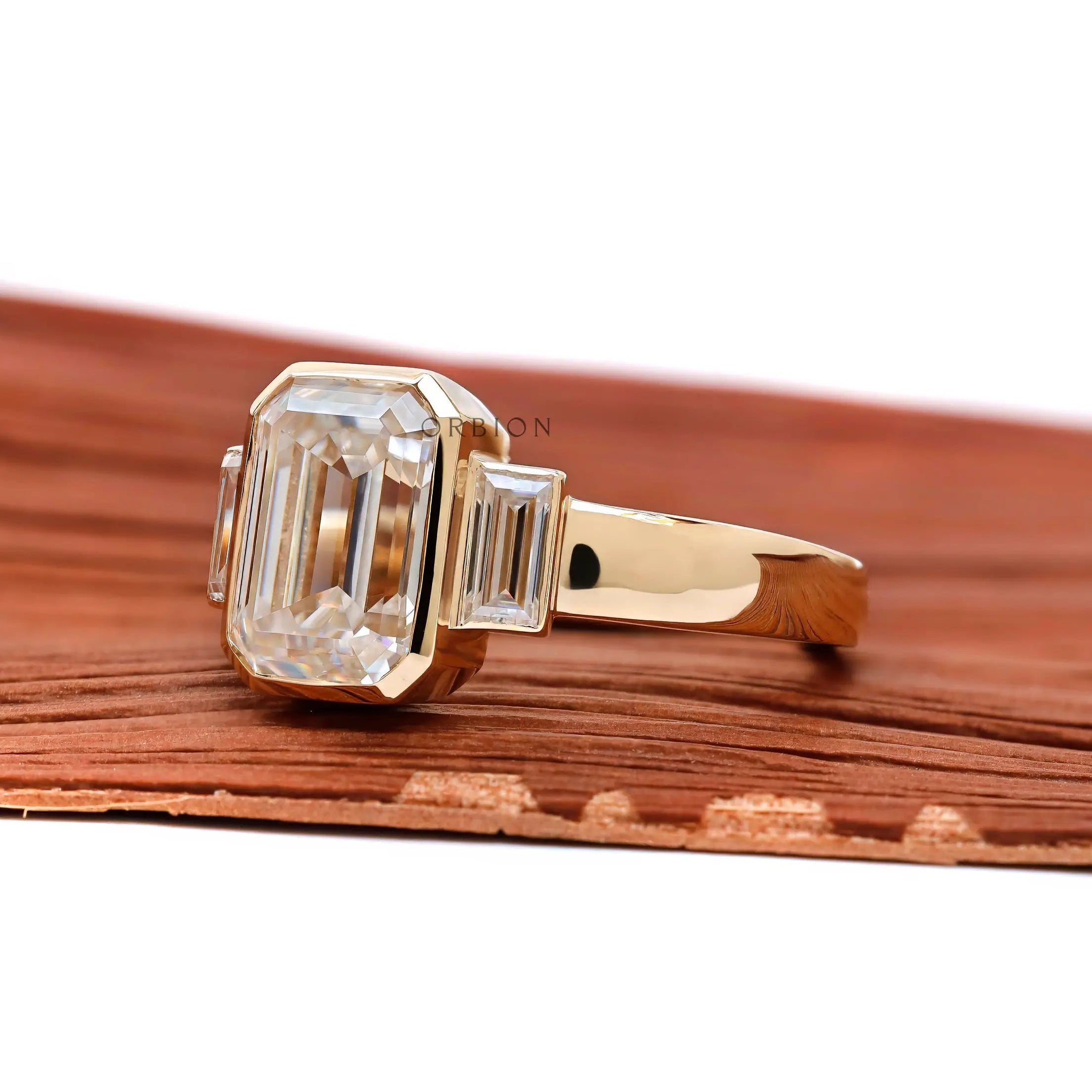 Emerald cut three stone thick band engagement ring yellow gold