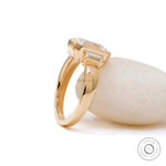 Bezel set three stone ring with baguette side stones