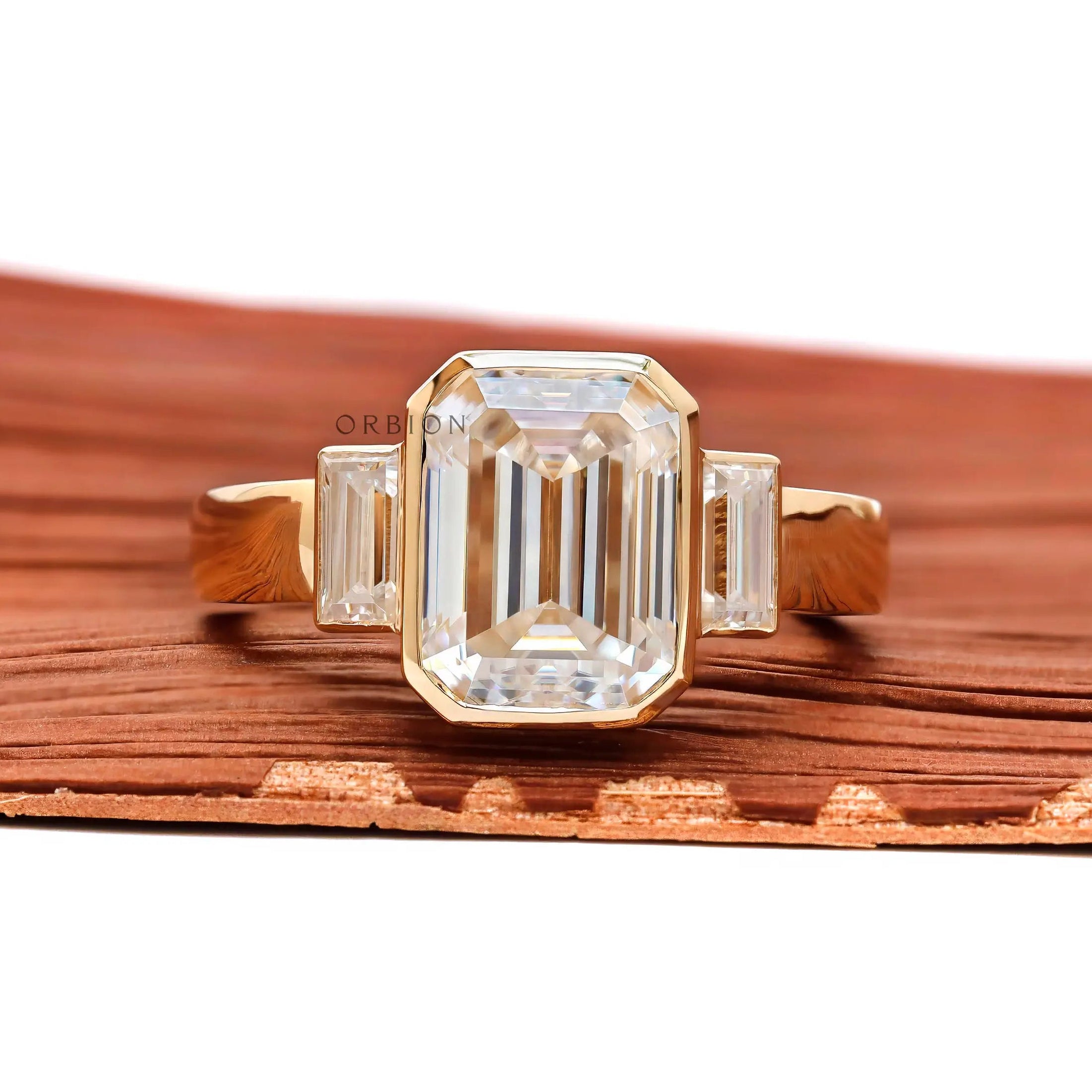 Emerald cut three stone bezel ring front view