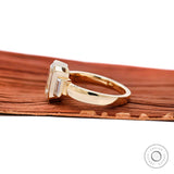 Side profile of emerald cut trilogy wedding ring yellow gold