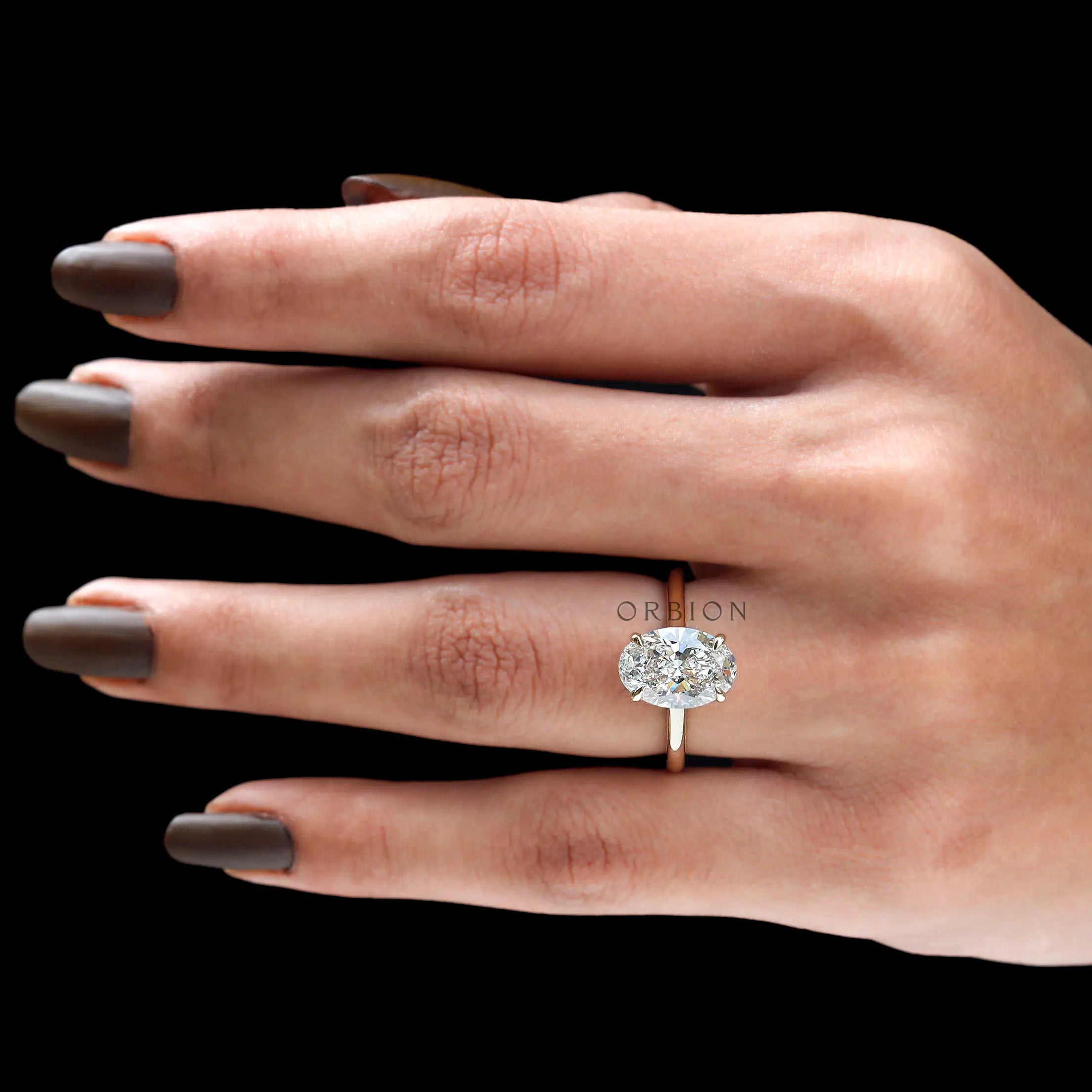 Cathedral setting oval diamond ring on finger