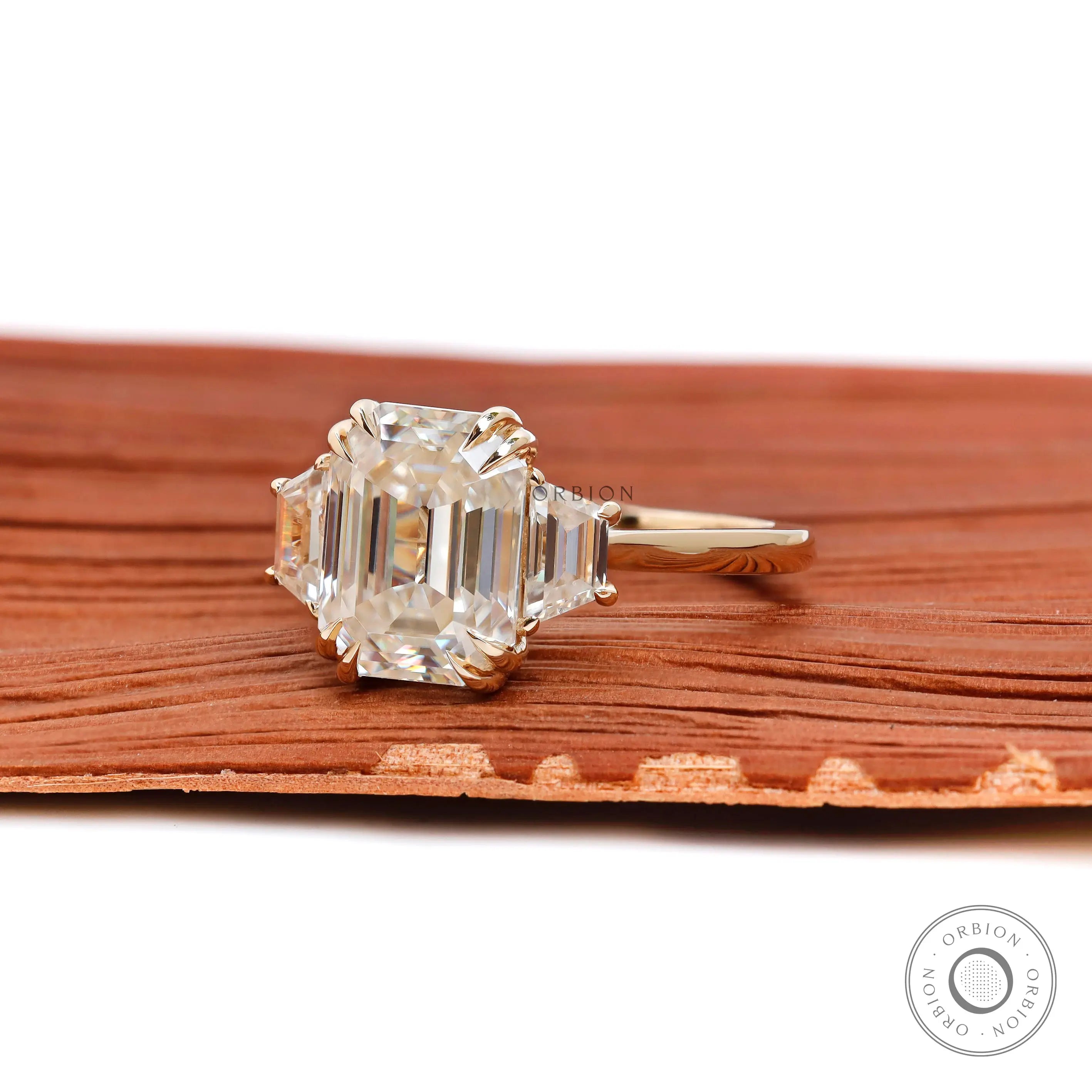 Three stone moissanite ring with step cut trapezoid accents