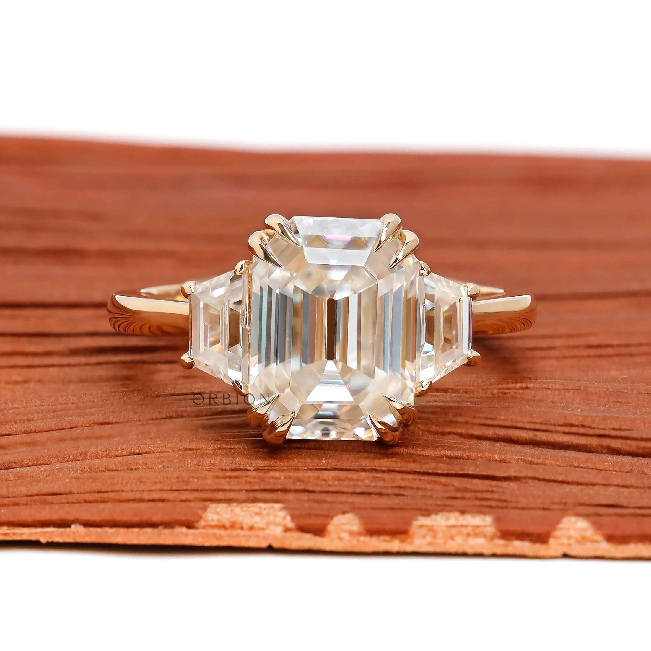 Emerald cut three stone cathedral engagement ring in 14K yellow gold