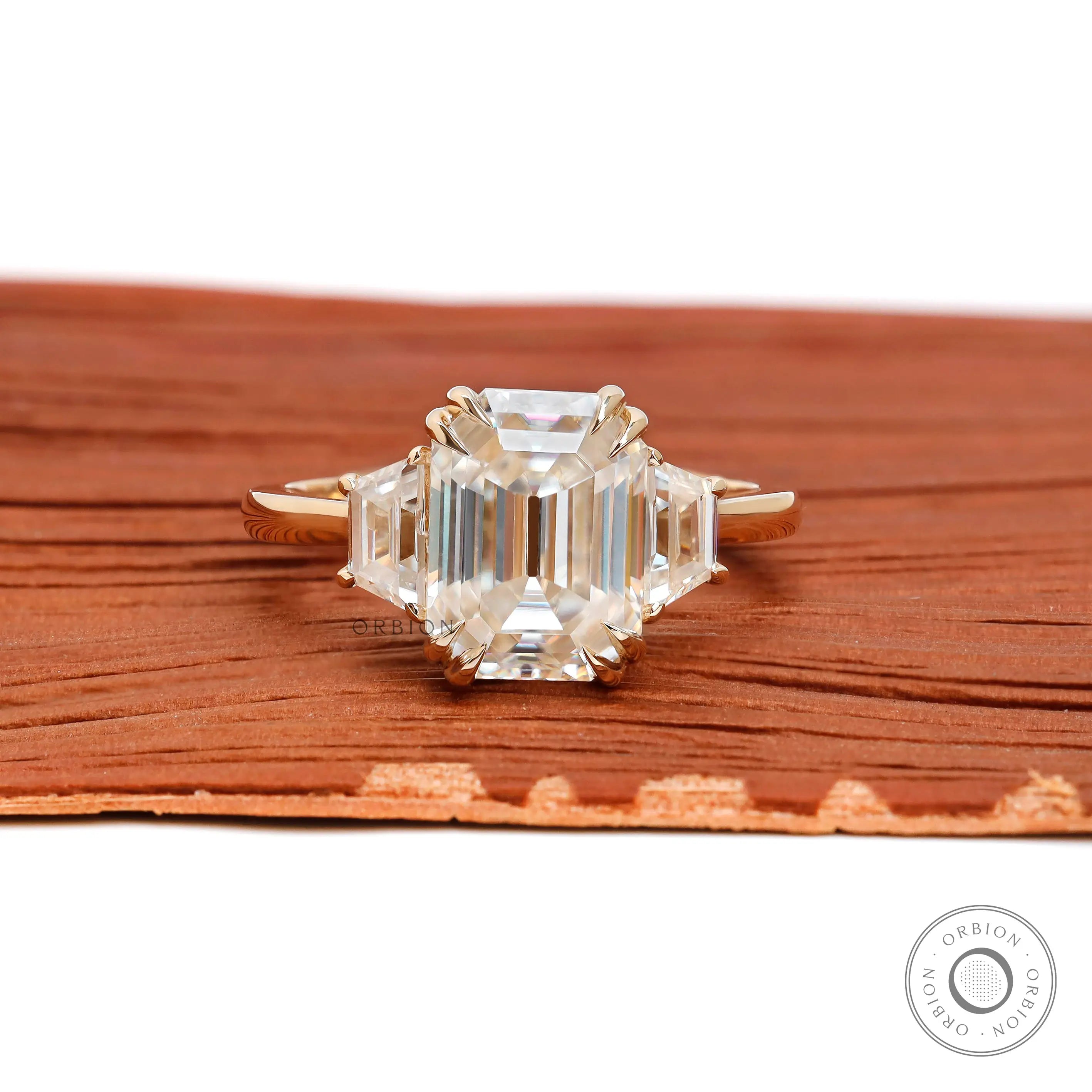 Emerald cut three stone cathedral engagement ring in 14K yellow gold