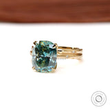 Elongated cushion moissanite ring with starburst halo and gold celestial band