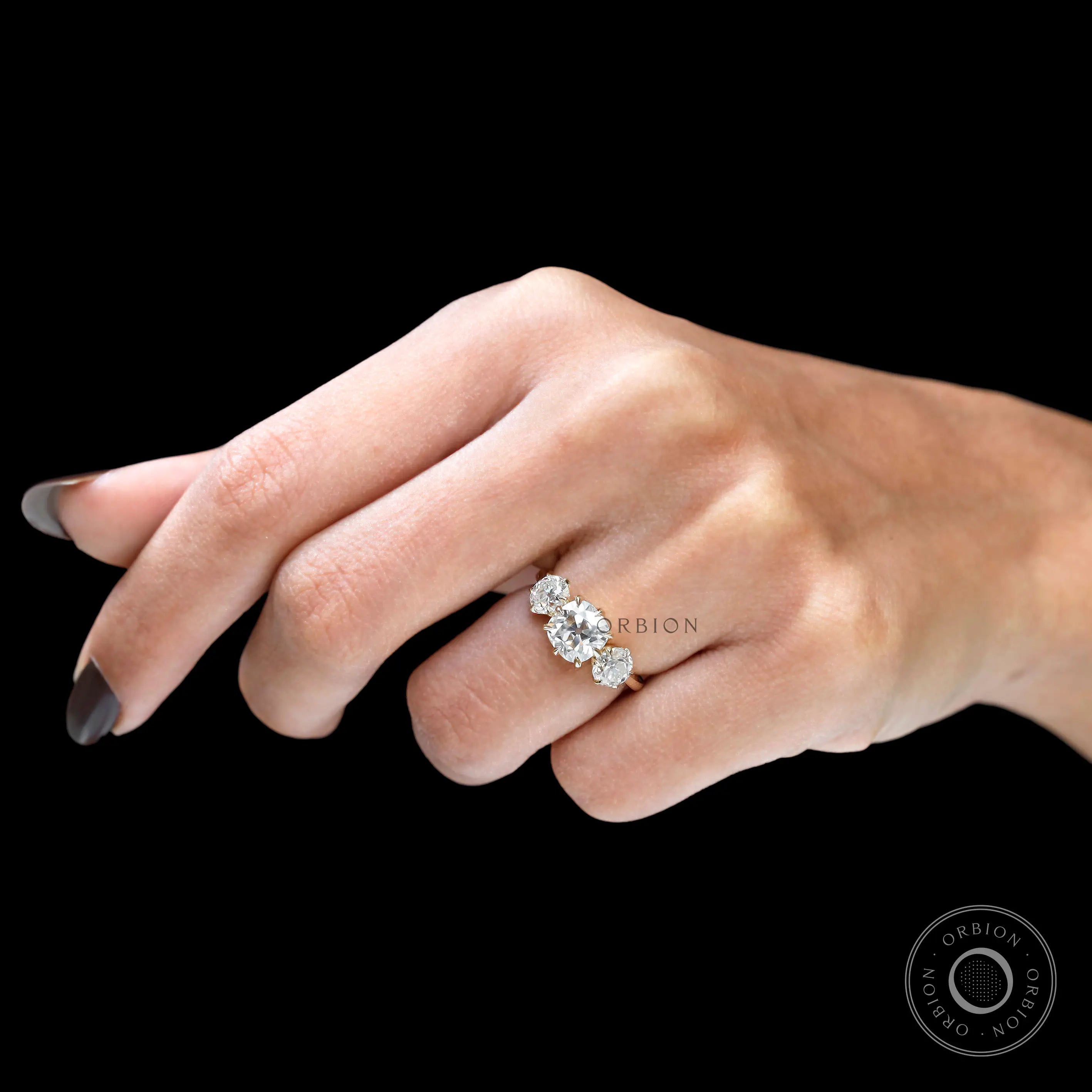Cushion moissanite three stone ring on hand close up