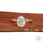 Oval cut bezel set lab diamond engagement ring in 14k yellow gold front view