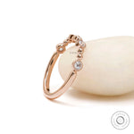 Beaded ball rose gold wedding band with round moissanite close up detail 