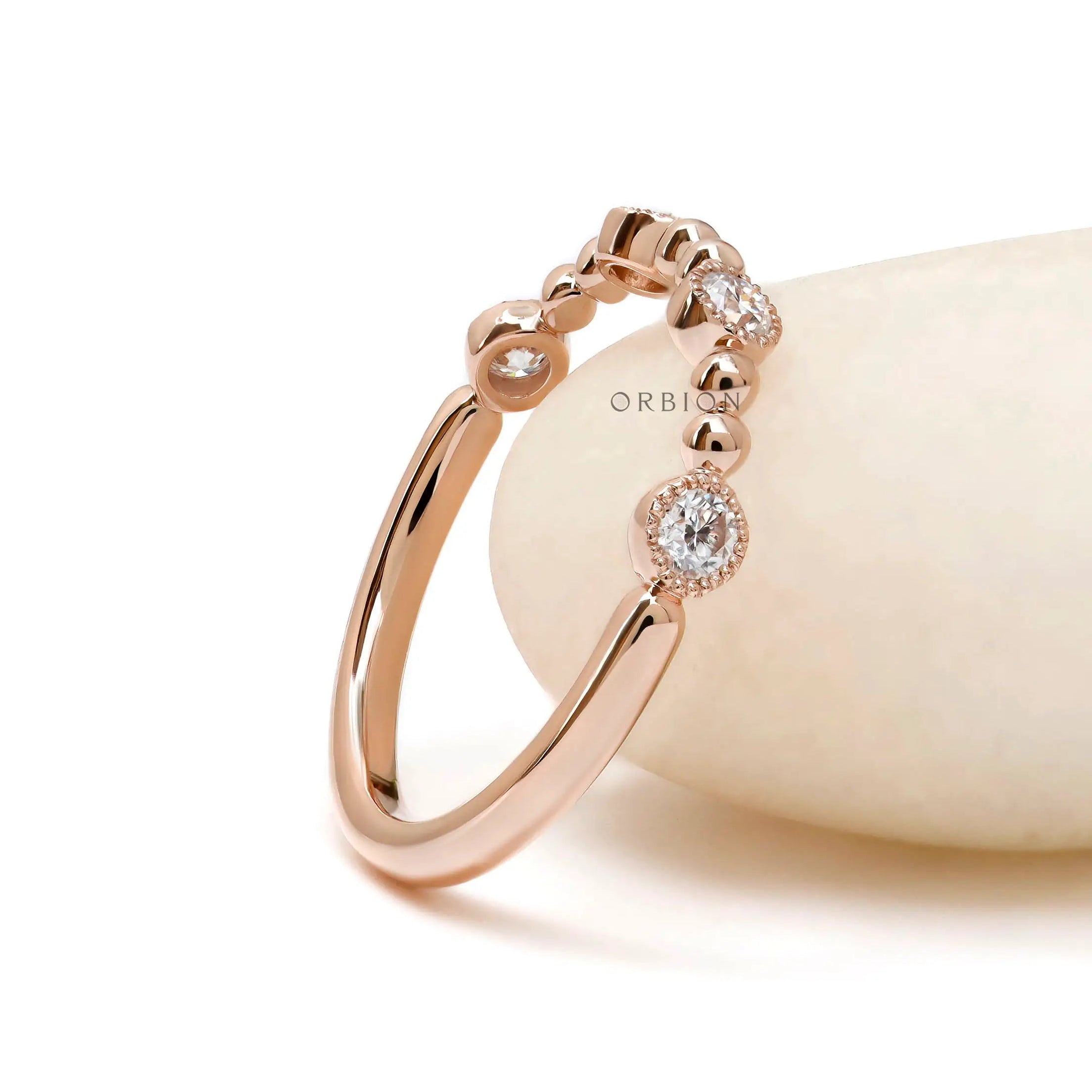 Beaded ball rose gold wedding band with round moissanite close up detail 