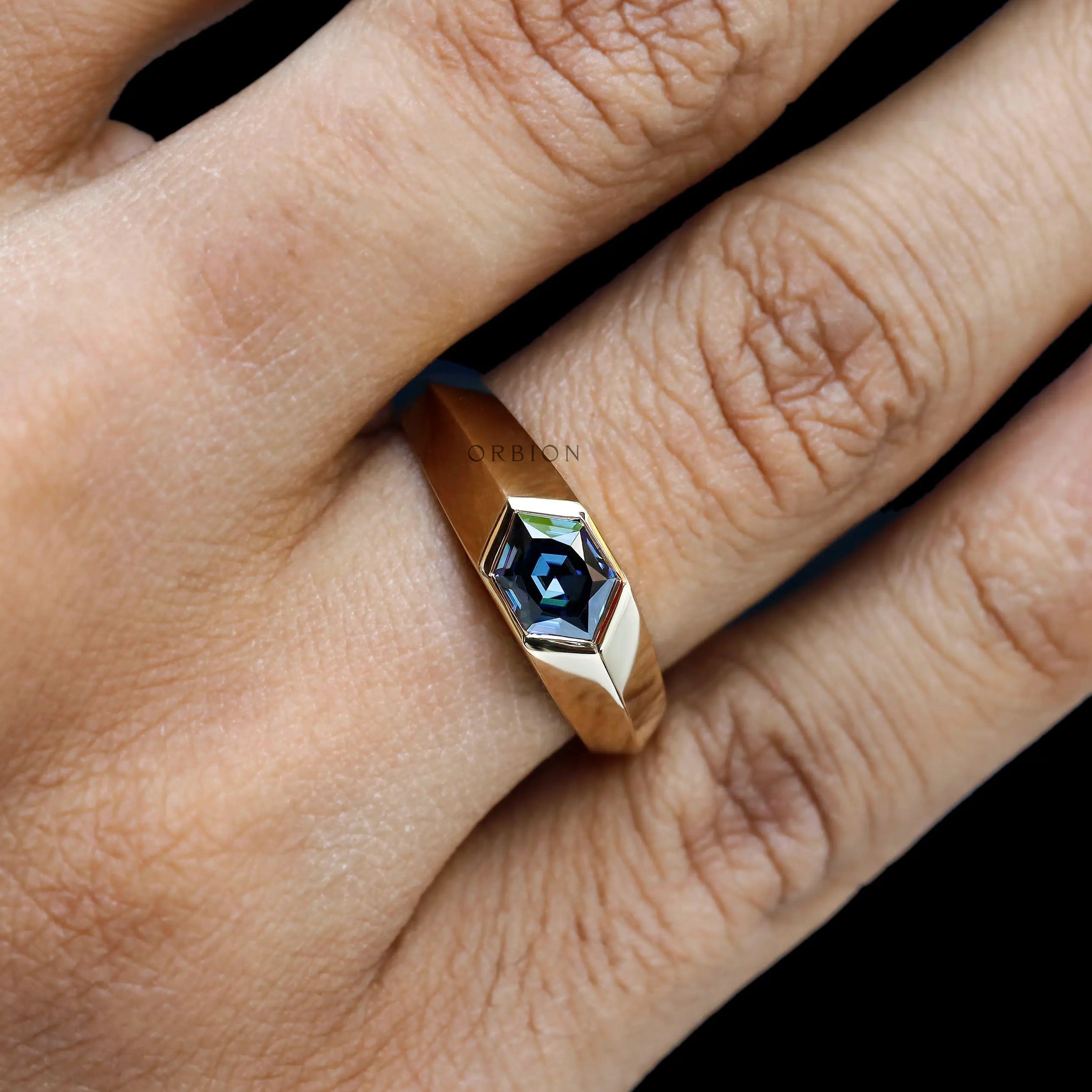 Close up of mens blue moissanite signet ring yellow gold