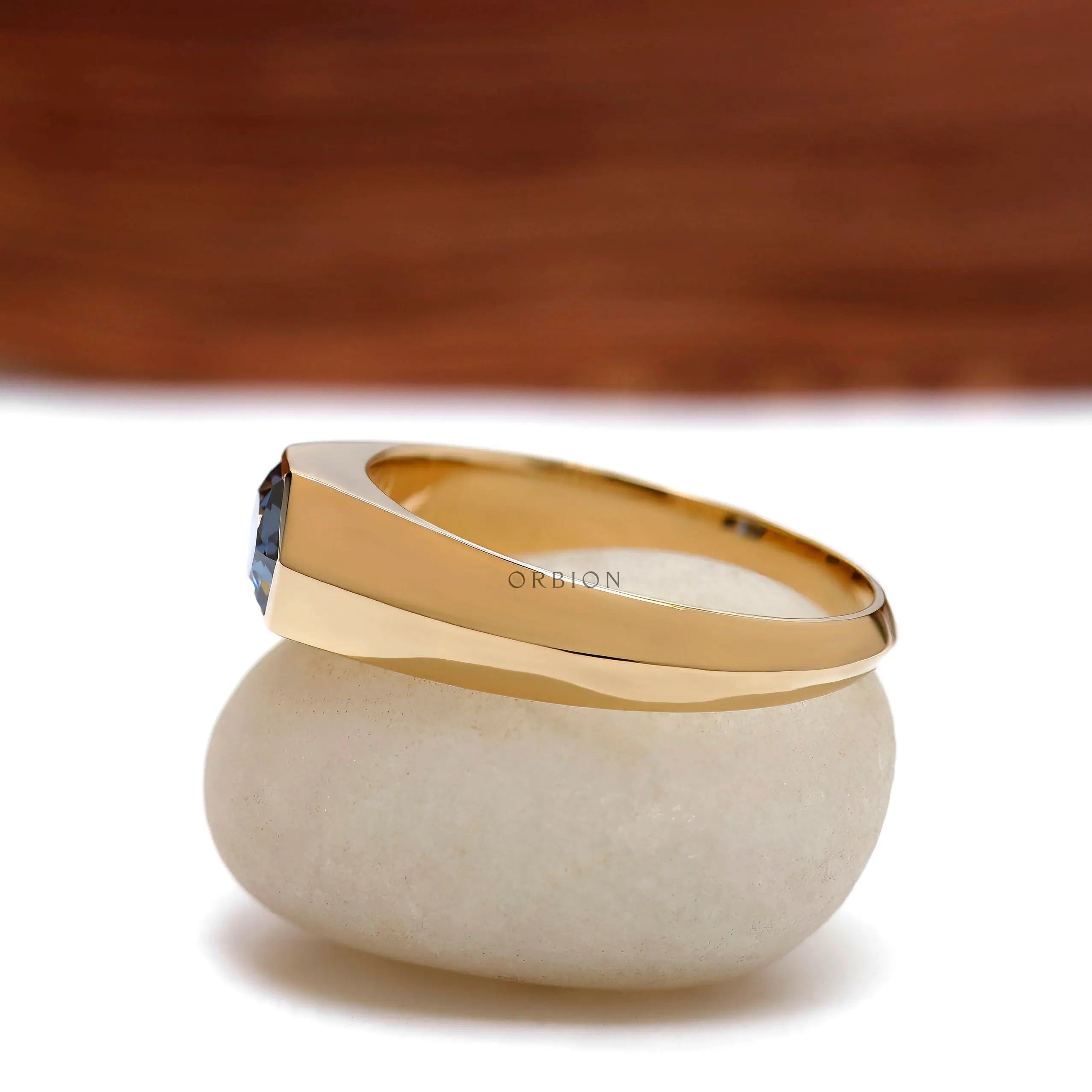 Side profile of men’s tapered gold band with hexagon bezel stone