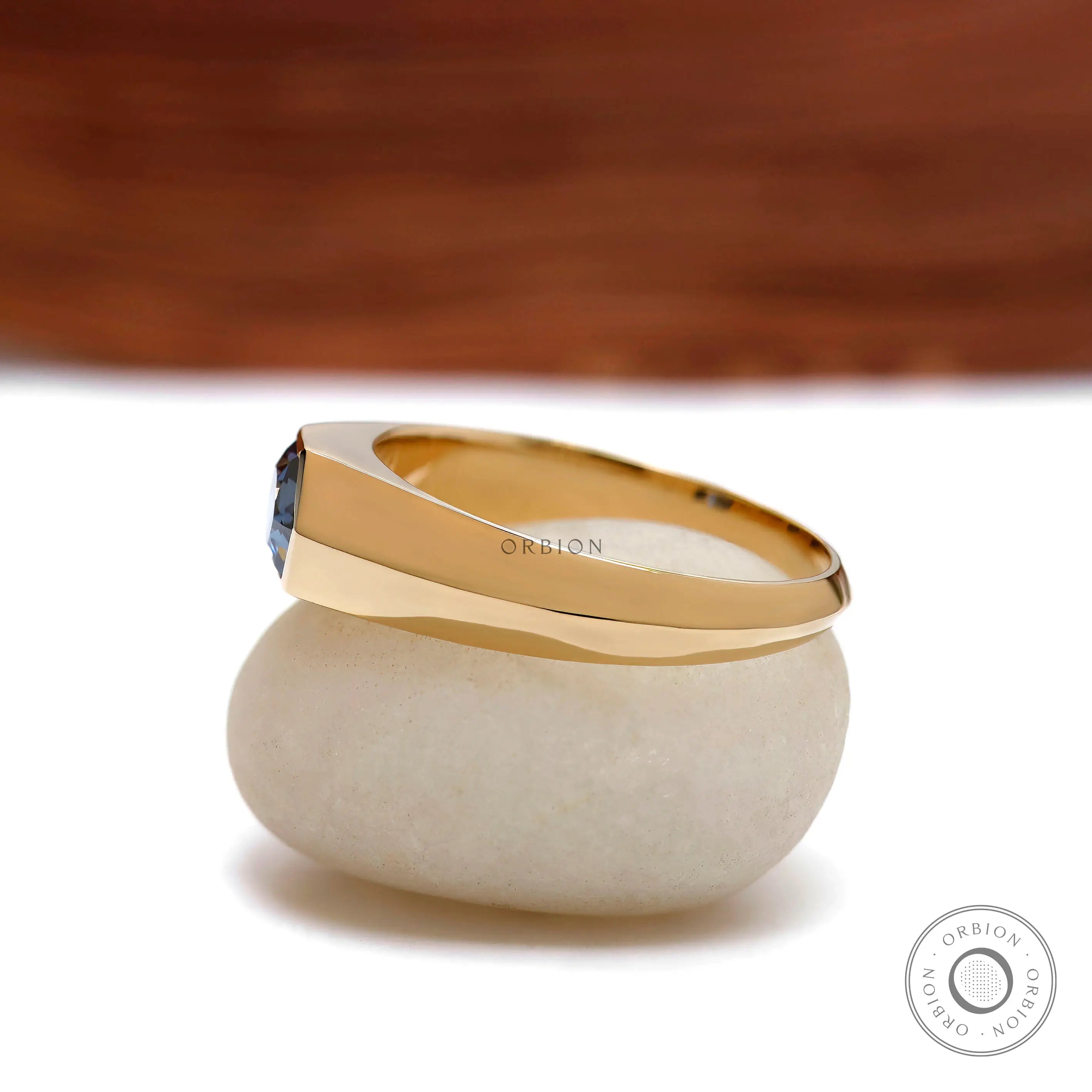 Side profile of men’s tapered gold band with hexagon bezel stone