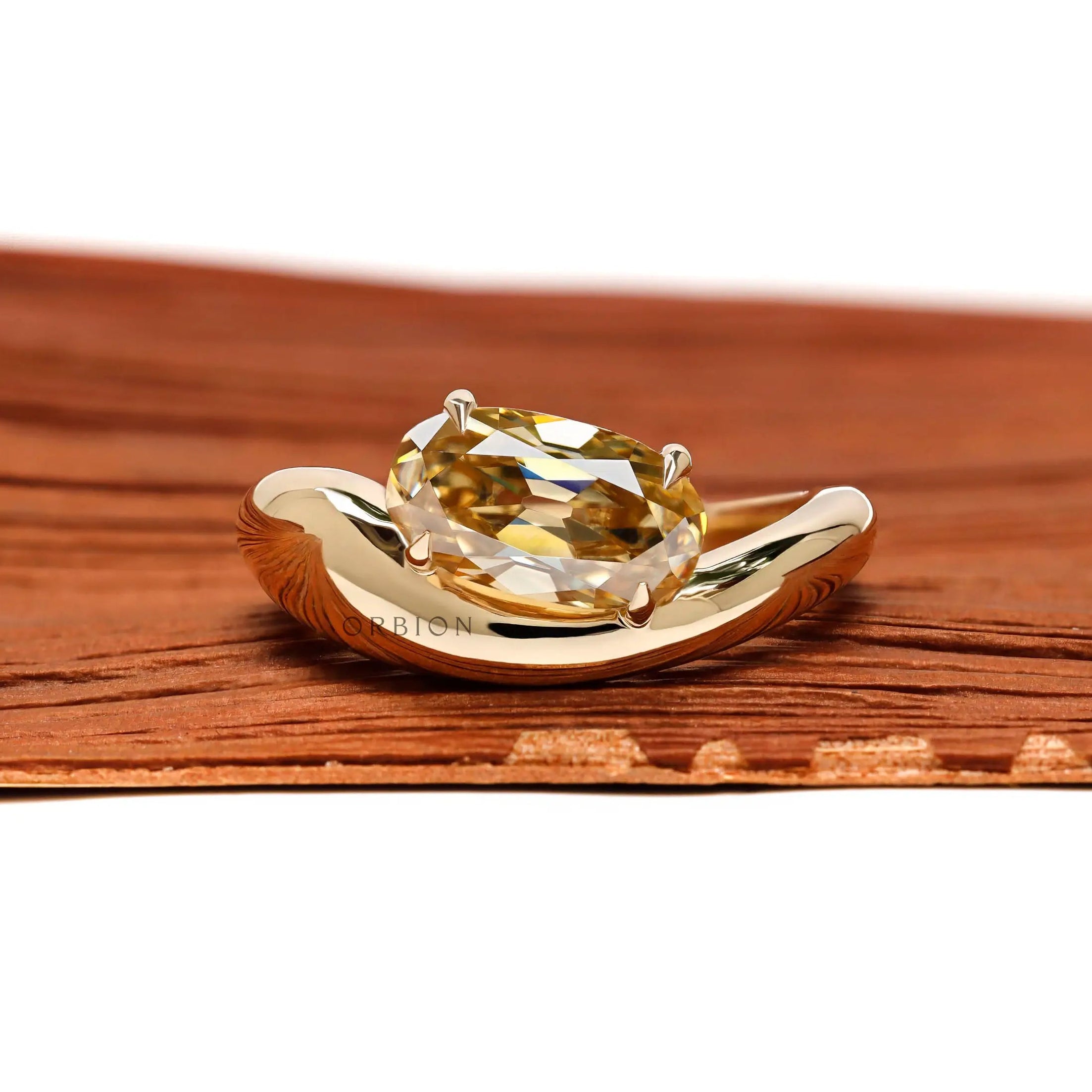 Modern chunky wave oval yellowish champagne moissanite engagement ring in 10K yellow gold front view