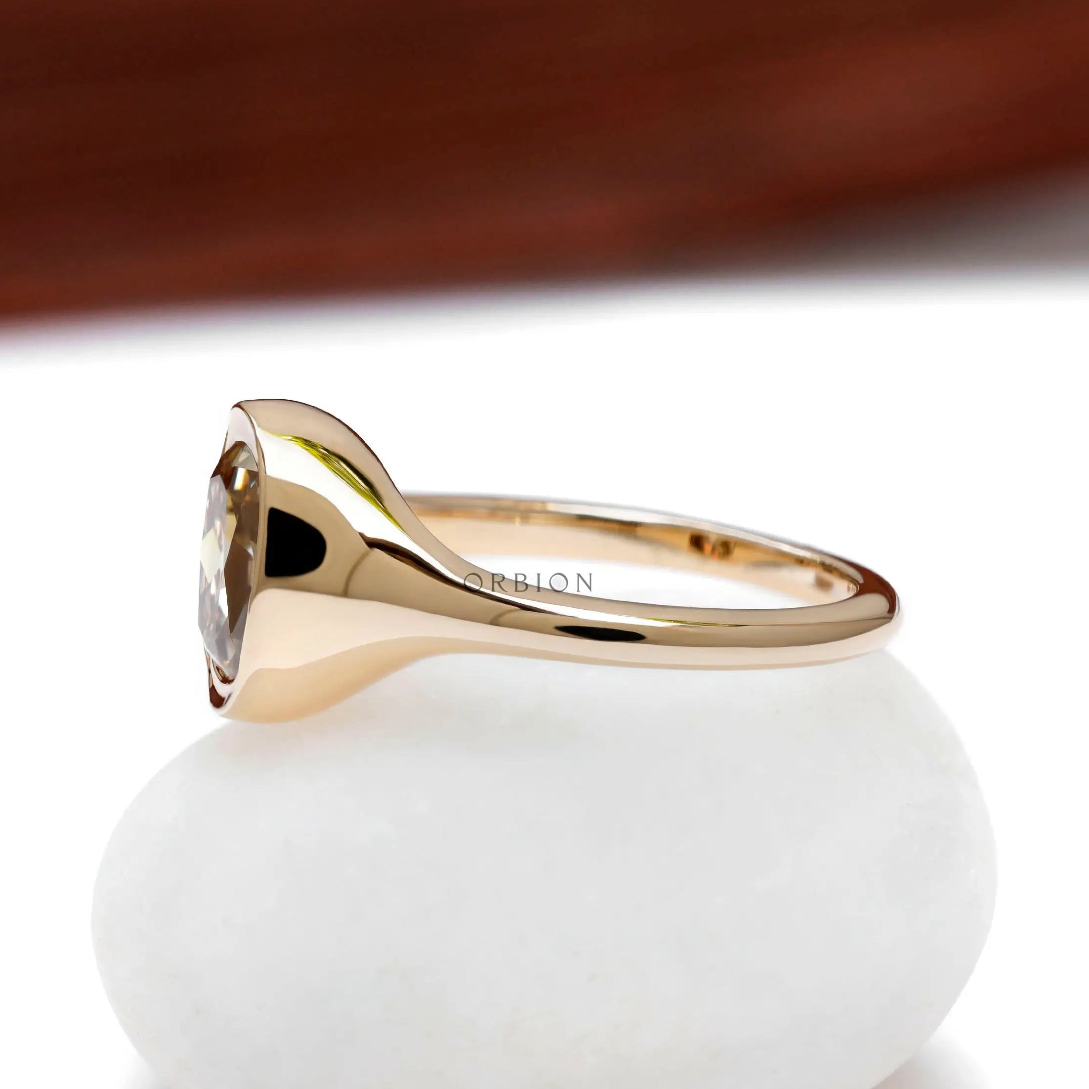 Bezel set elongated cushion champagne moissanite ring in 10k yellow gold