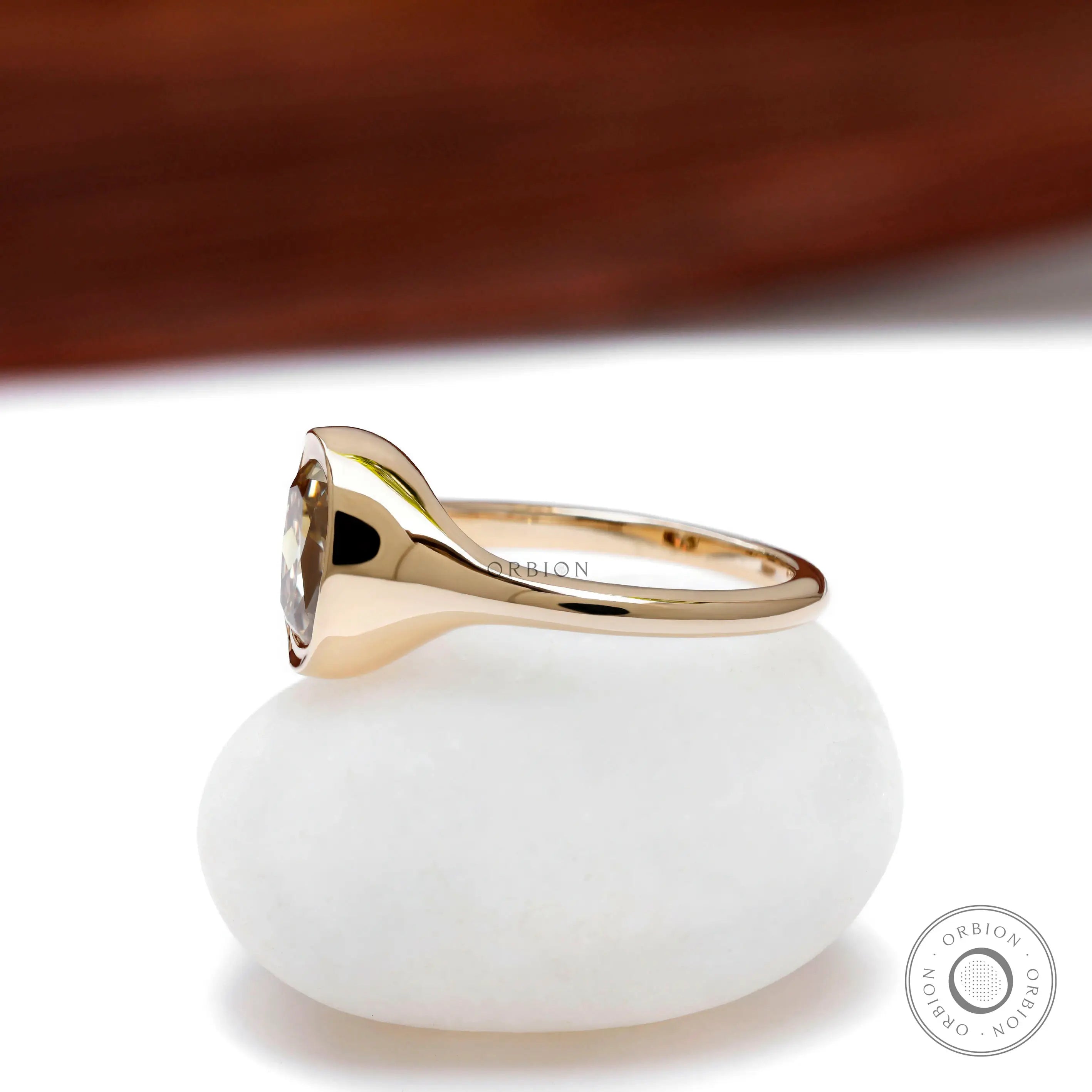 Bezel set elongated cushion champagne moissanite ring in 10k yellow gold
