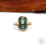 Front view of green moissanite floating half bezel ring