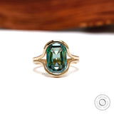 Front view of green moissanite floating half bezel ring
