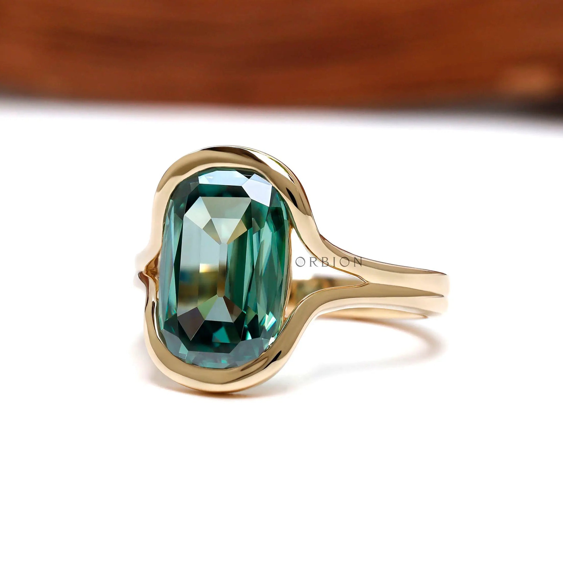 Angled front view of elongated green moissanite gold ring