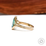 Side view of floating half bezel green moissanite ring