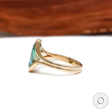 Side view of floating half bezel green moissanite ring